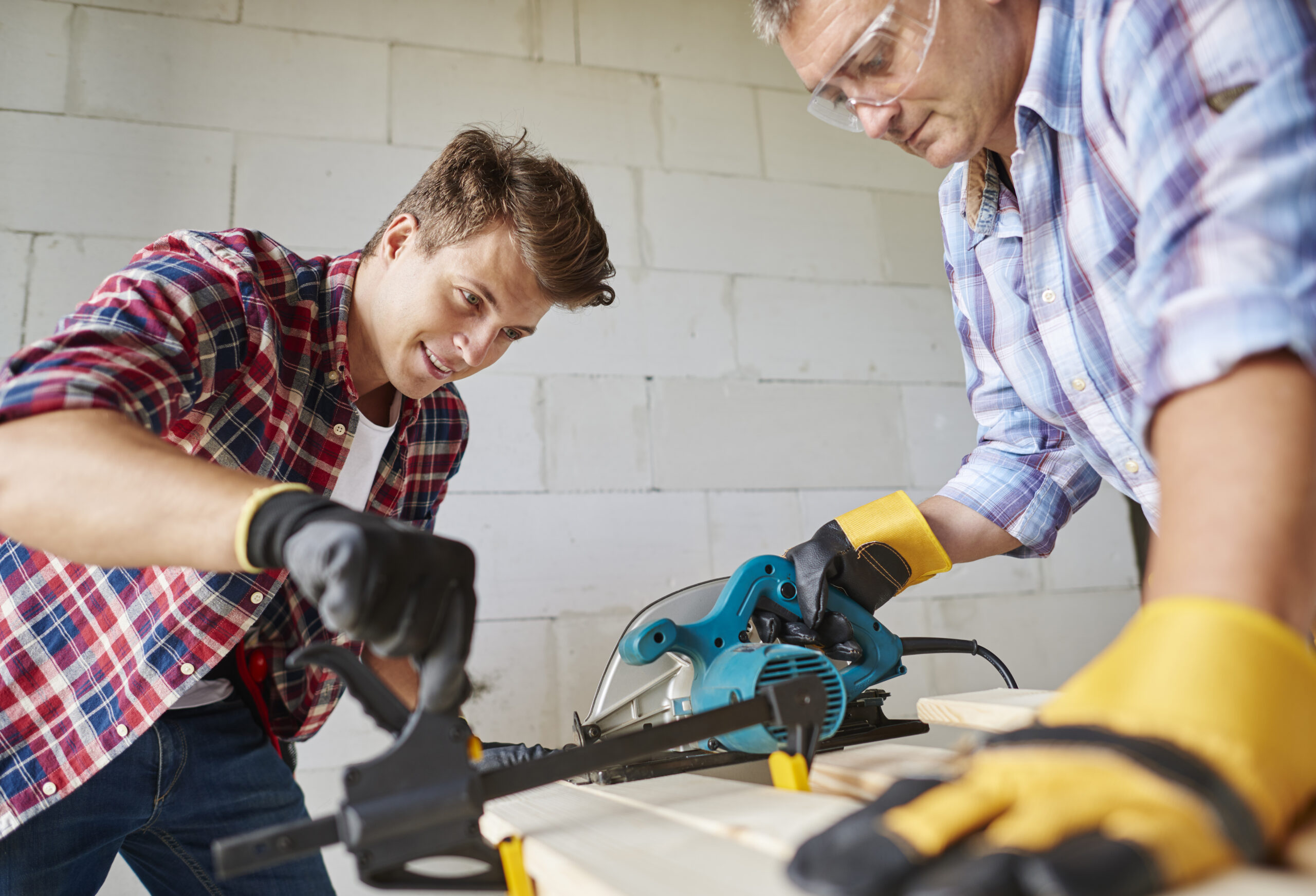 Sawing wooden plank with electric saw